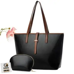 large black PU leather tote bag with brown straps and a matching small pouch., Couva